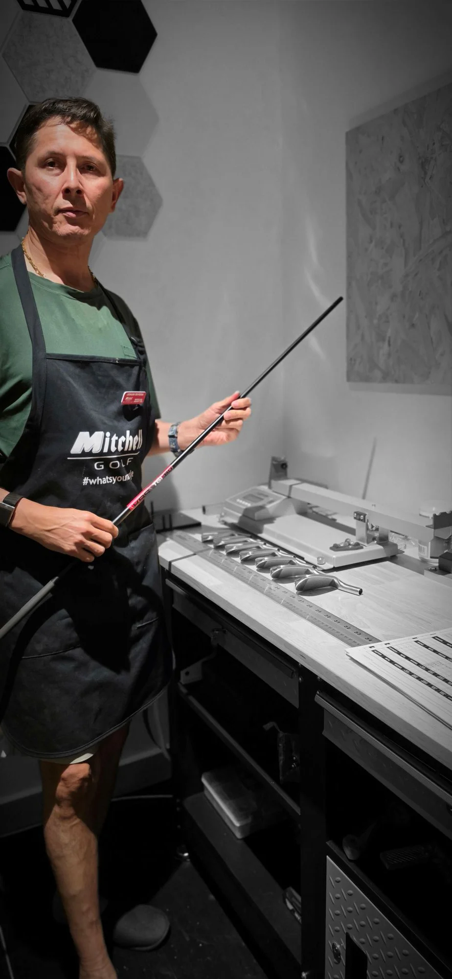 Johan Rivera holding a golf shaft at the ASUBURE clubmaking bench