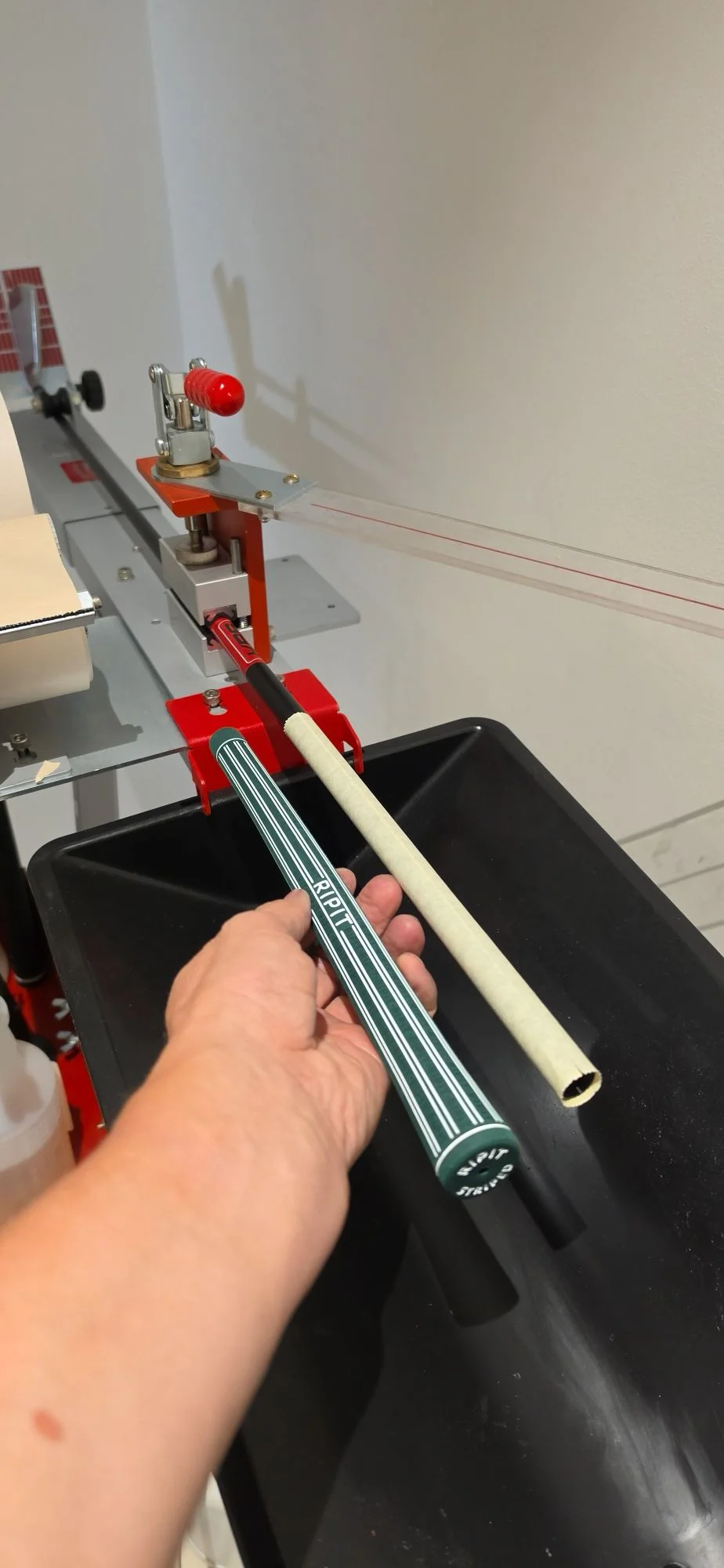 Golf grip and shaft held at workshop equipment during precise component work
